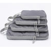 A set of four gray vertical travel organizer bags with adjustable straps and buckles.