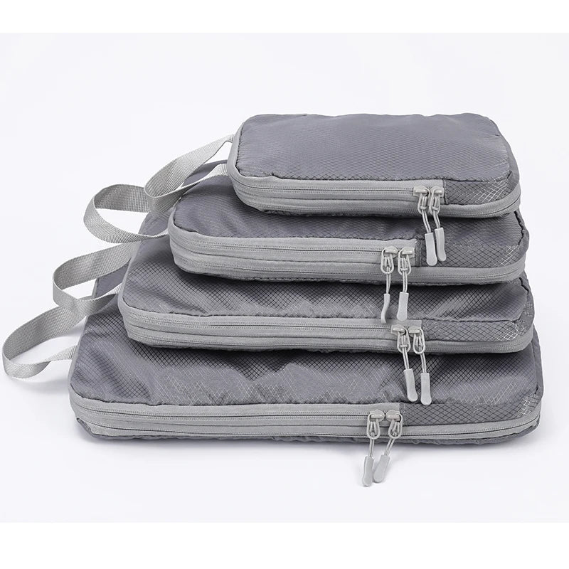 A set of four gray vertical travel organizer bags with adjustable straps and buckles.
