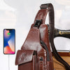 A brown genuine leather sling backpack for men is shown on a wooden surface.