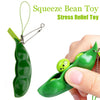 A hand holds a green squeeze bean toy stress relief fidget toy keychain.