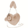 A light beige faux fur heart-shaped crossbody purse with a dangling chain strap.
