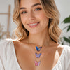 A woman models a necklace featuring colorful butterfly enamel charms.