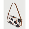 A beige and black cow print single shoulder bag with a brown adjustable strap.
