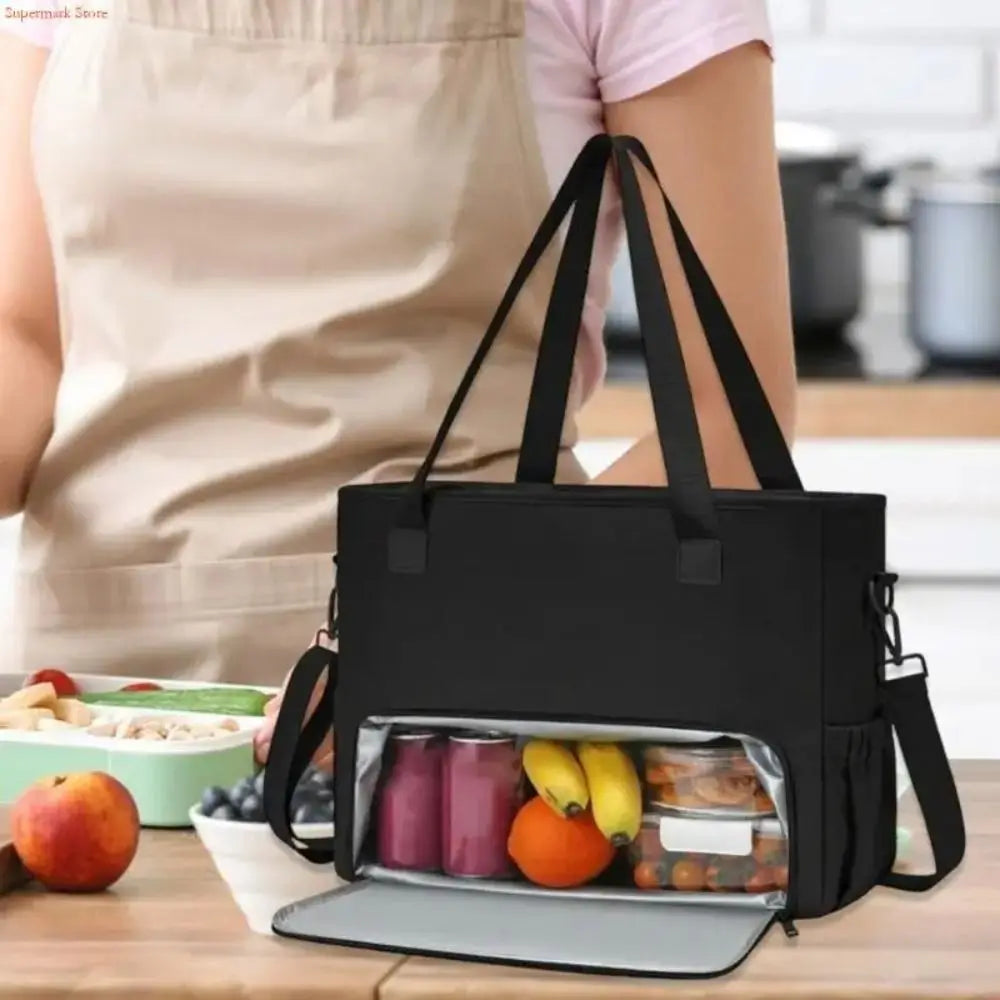 A black insulated 2-in-1 lunch tote bag is shown open, revealing various food items and a laptop sleeve.