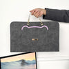 A gray slim PU laptop protective case with a cat face design is held by a hand.
