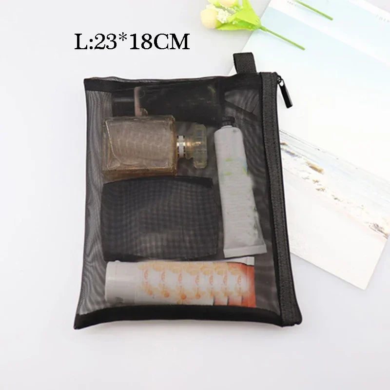 Black mesh cosmetic storage pouch containing various small items like a glass, brush, and rolled material.