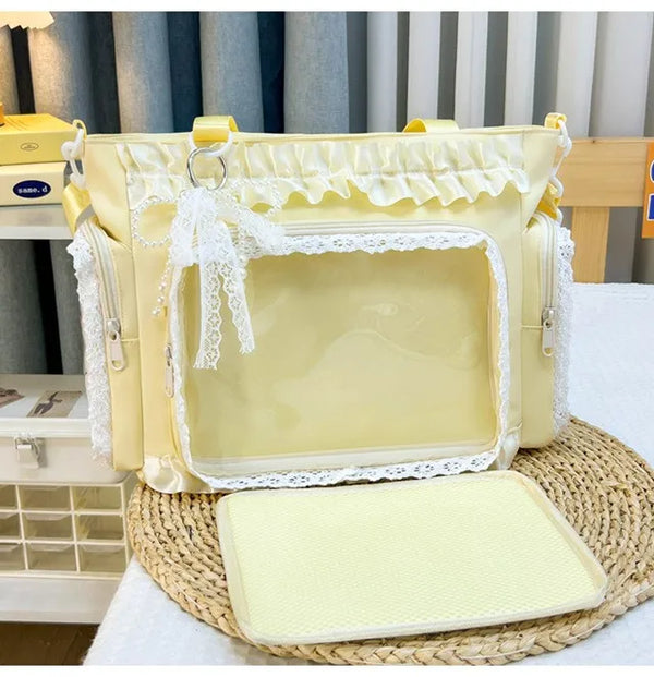 A yellow Y2K lace crossbody shoulder bag with white lace trim resting on a woven mat.