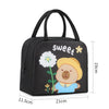 Black insulated lunch bag featuring a cute cartoon capybara character with a yellow cap and green stem.