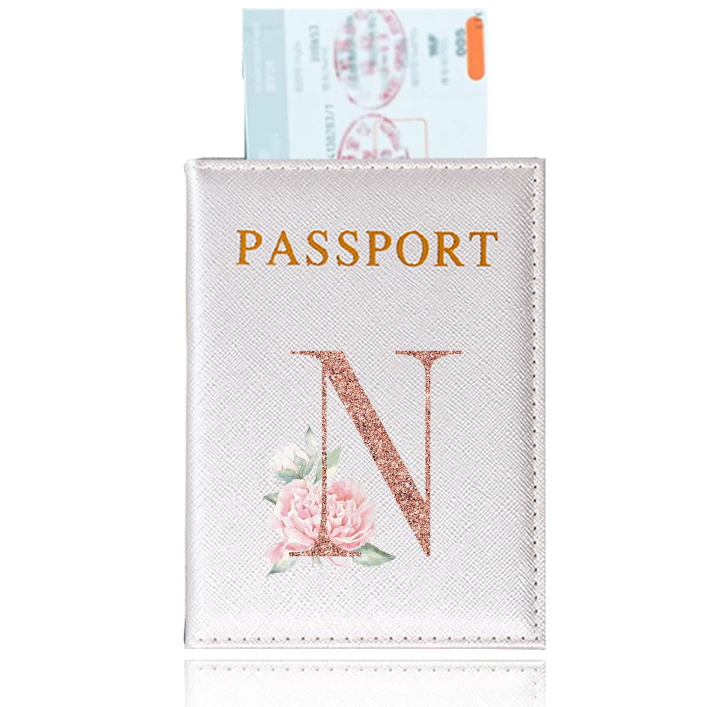 A light pink elegant PU travel passport holder featuring a gold embossed letter N and a pink rose design.
