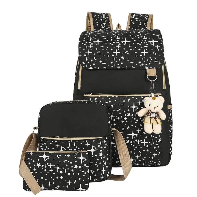 A black canvas student backpack decorated with white stars and featuring a teddy bear charm.