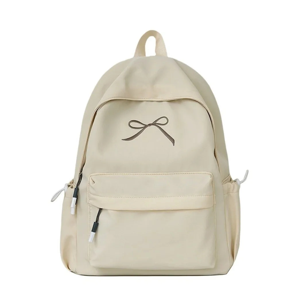 A beige portable embroidered backpack for students with a drawstring closure and pockets.