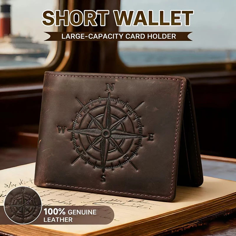 A dark brown leather short wallet with a compass design resting on a wooden surface.