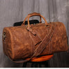 Braune Vintage-Ledertasche mit Ledergriffen auf einer Holzoberfläche.