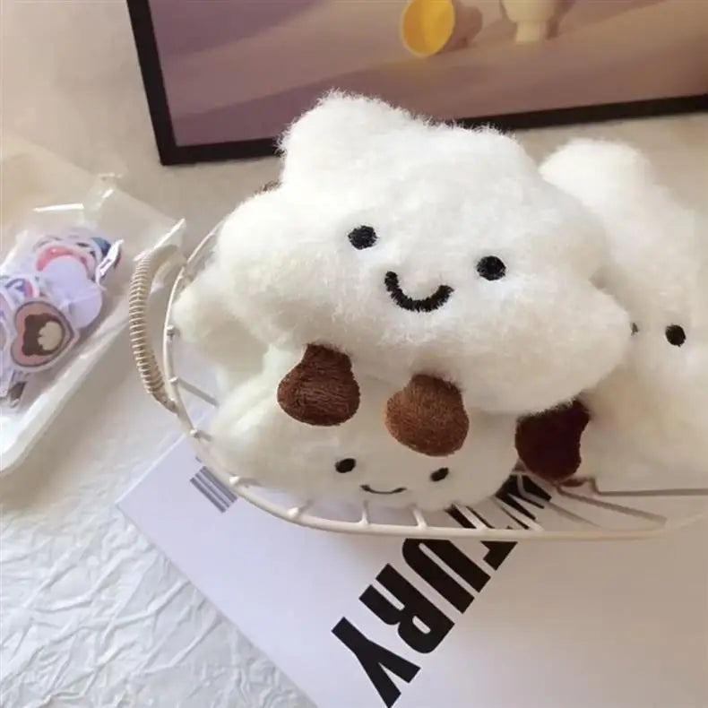 A white fluffy cloud shaped plush toy with brown spots is displayed on a silver wire tray.