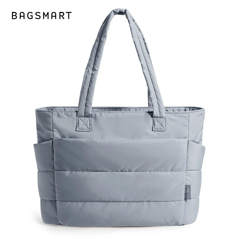 Sac fourre-tout rembourré et matelassé gris avec poignées rembourrées, présenté sur fond blanc.