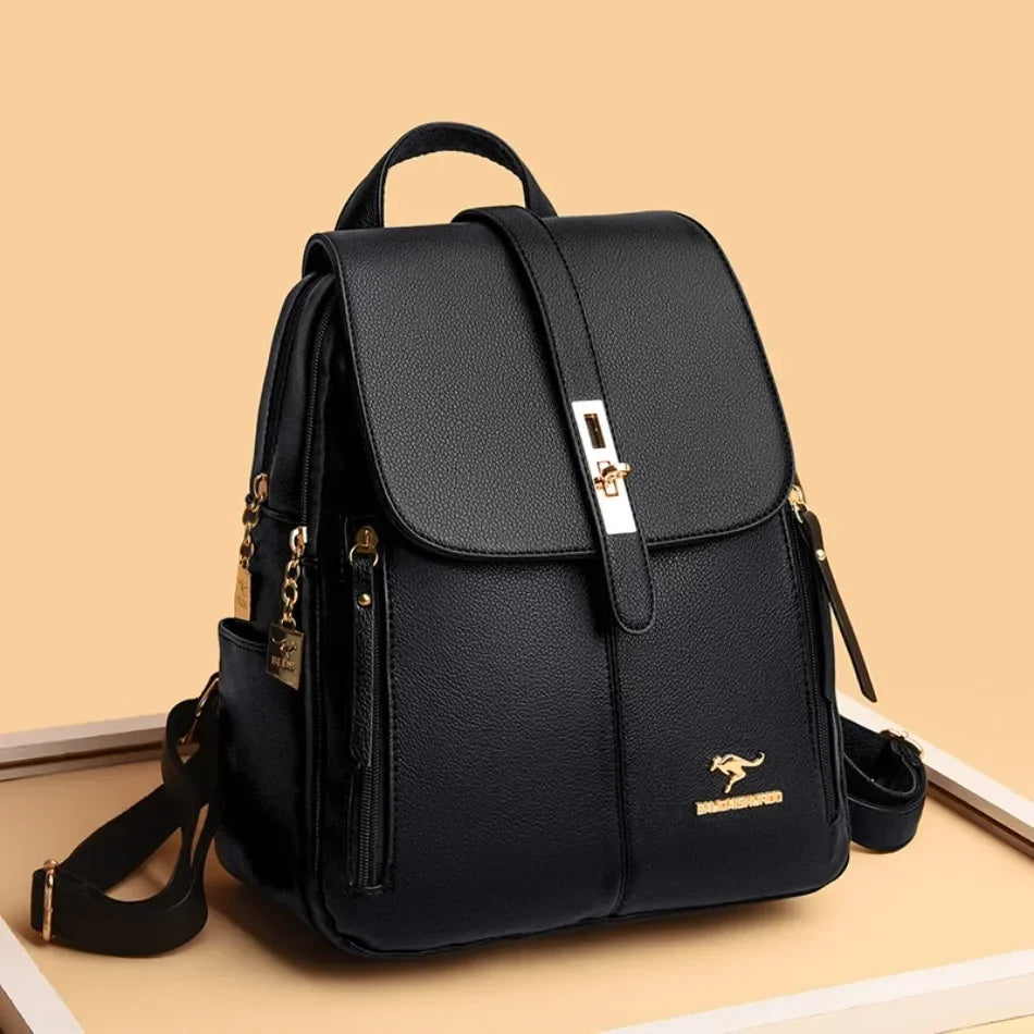 Sac à dos en cuir microfibre noir vintage avec quincaillerie dorée sur une surface en bois clair.