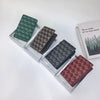 A collection of four geometric print passport wallets in shades of green, brown, and maroon displayed on a white surface.