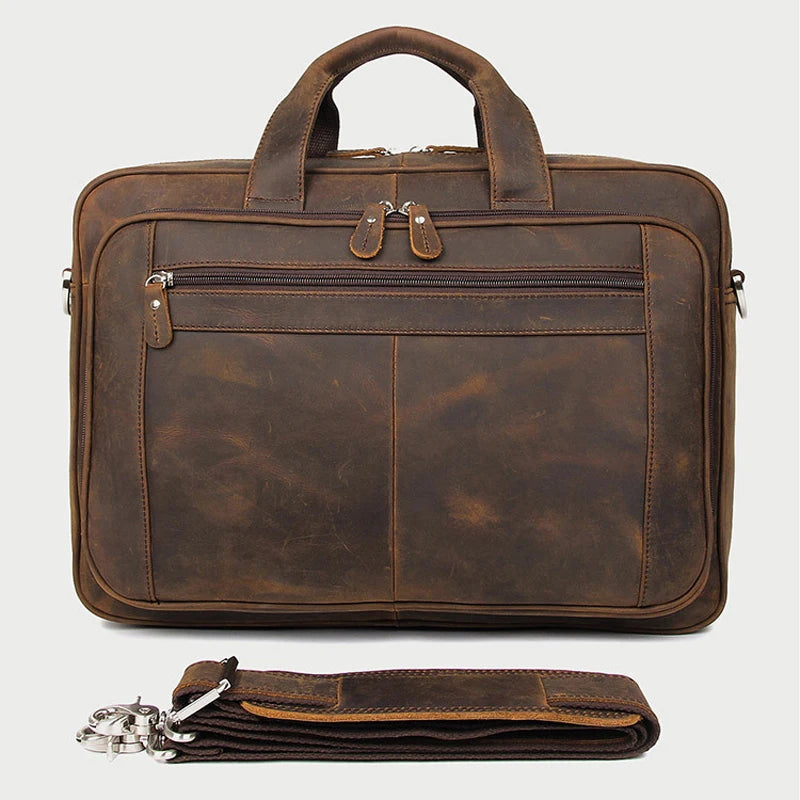 A brown genuine leather briefcase with a handle and flap, shown next to a folded leather strap.