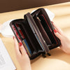 A brown vintage PU leather zippered wallet with multiple compartments is held open on a light wooden surface.