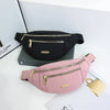 A pink lightweight nylon crossbody fanny pack is displayed on a white surface.