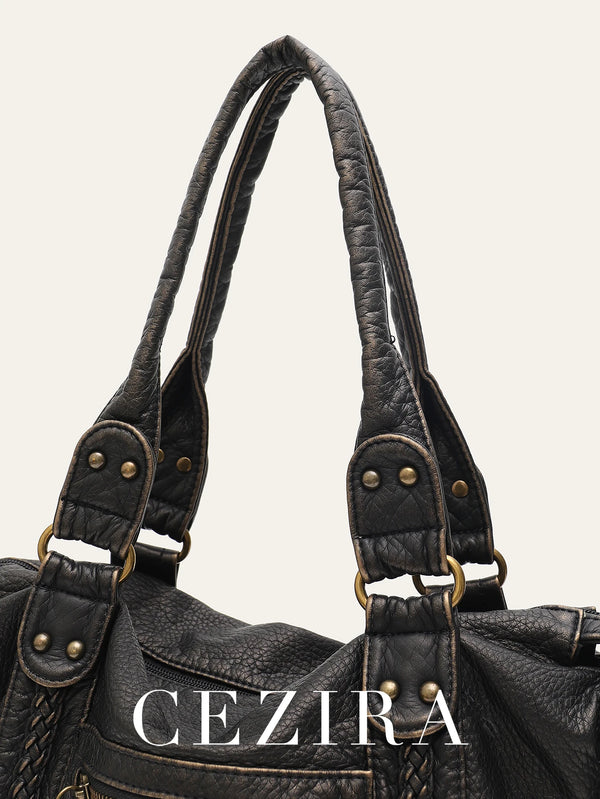 A close-up of a dark brown vintage PU leather tote bag with leather straps and brass hardware.