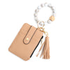 Tan leather card holder with a gold keychain and a white beaded bangle