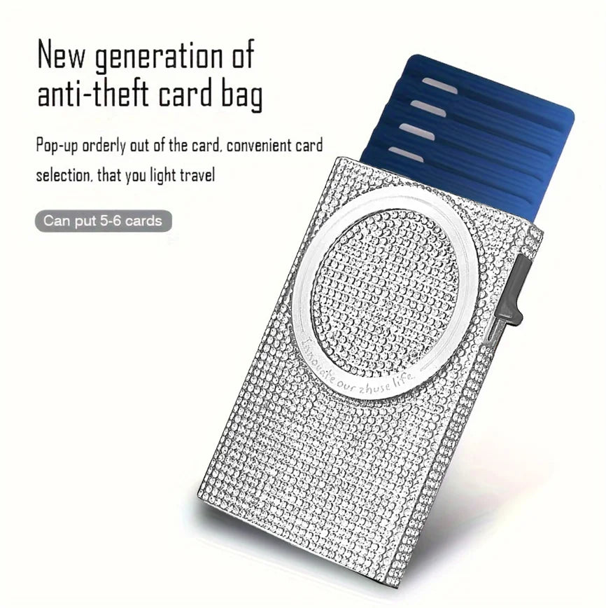 A silver magnetic card holder wallet with a clear circular window and a blue card bag attached.