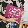 A hand holds a magenta zippered organizer pouch for plugs, cables, and chargers against a person wearing a black and white pa