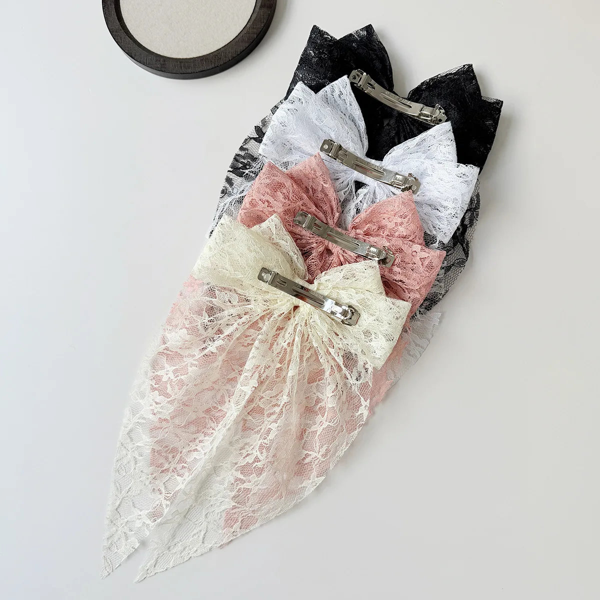 Zarte Spitze-Haarspange mit rosa und weißer durchscheinender Stoffverzierung.