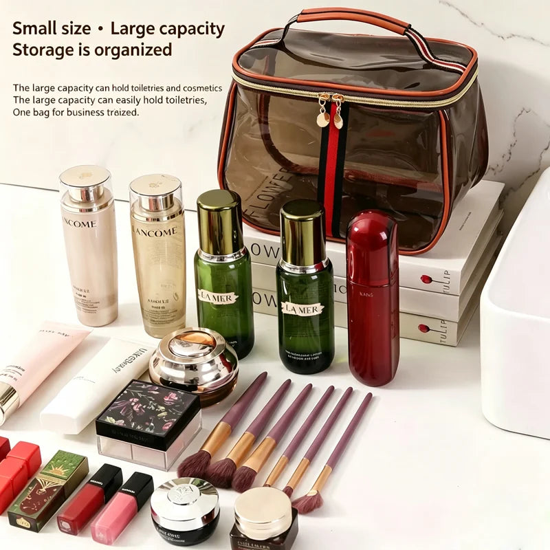 A transparent cosmetic bag with a brown and black design is shown alongside various makeup products and brushes.