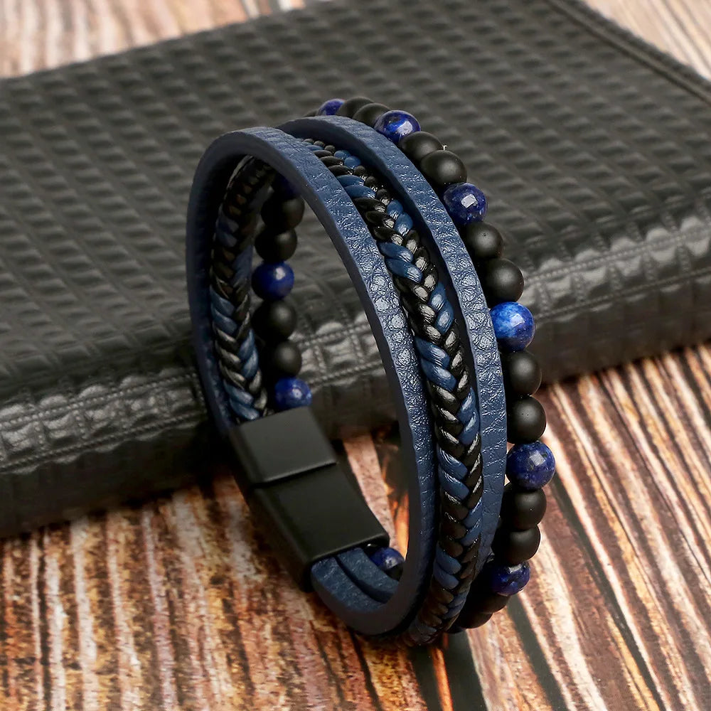 A stack of dark blue and black leather bracelets with tiger eye beads resting on a dark surface.