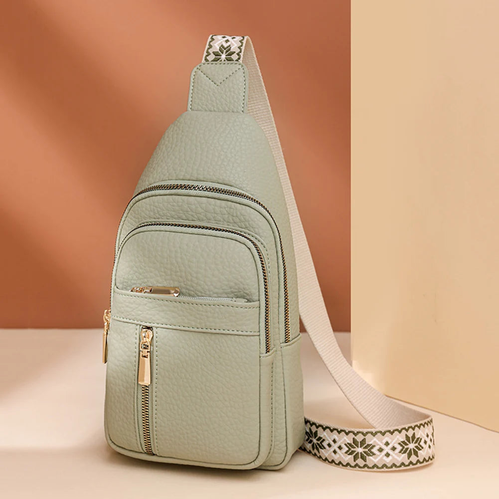 A light sage green PU leather crossbody chest bag with a patterned strap and zipper details.