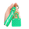 A hand holds a bright green silicone heart beach bag with a gold keychain.