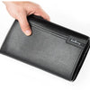 A hand is holding a black leather business card clip wallet.