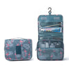 A teal multi-compartment travel pouch with a floral print featuring pink flamingos and various compartments.