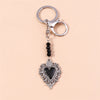 Silver gothic steampunk heart keychain with a black sun eye pendant