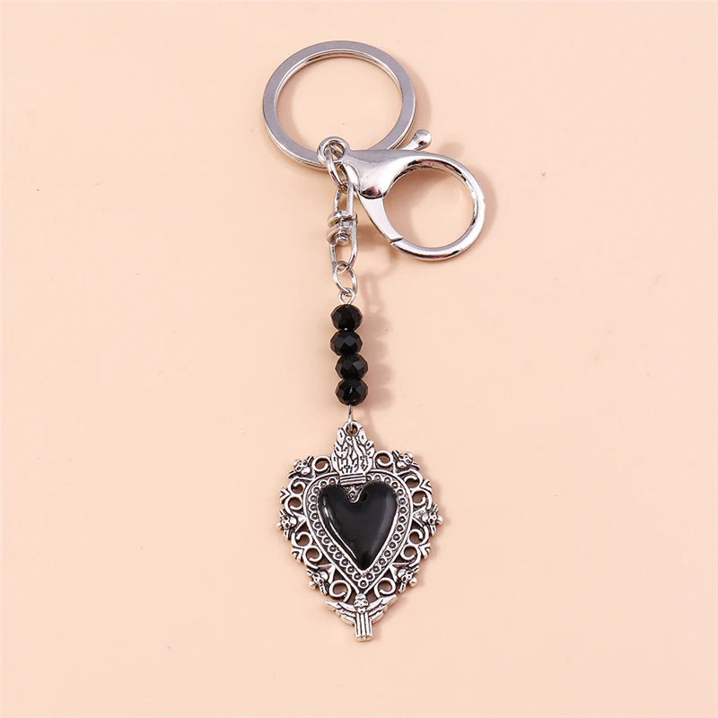 Silver gothic steampunk heart keychain with a black sun eye pendant