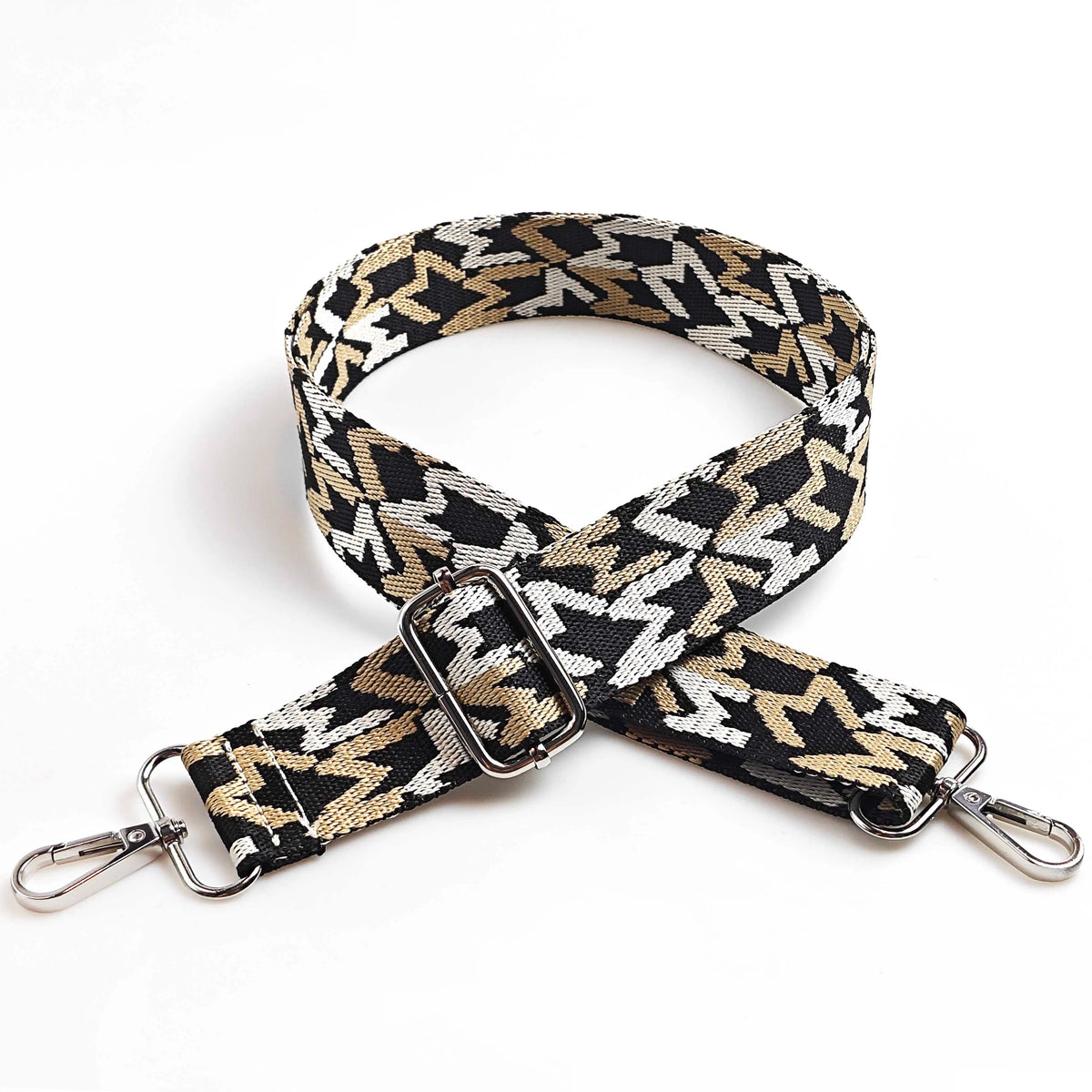 A black and gold jacquard patterned adjustable crossbody bag strap with silver hardware.