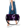A purple and black duffle bag featuring a butterfly print carried by a person.
