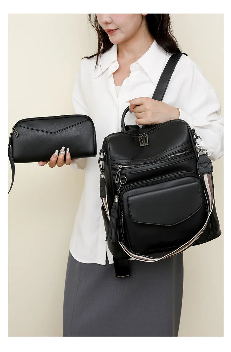 A woman holds a black retro PU leather travel backpack with tassel detail against a light background.
