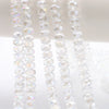 Clear AB faceted crystal glass beads in a wheel shape strung together for jewelry making