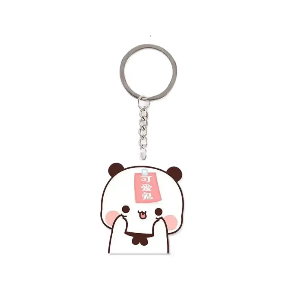 A white and pink cartoon panda resin keychain charm with a tag.
