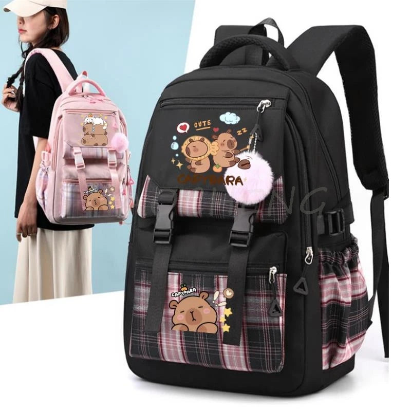 A black canvas backpack featuring a cute capybara print and pink accents, shown next to a person.