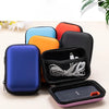 A collection of black, blue, orange, and red PU hard cases for portable SSDs displayed on a light surface.