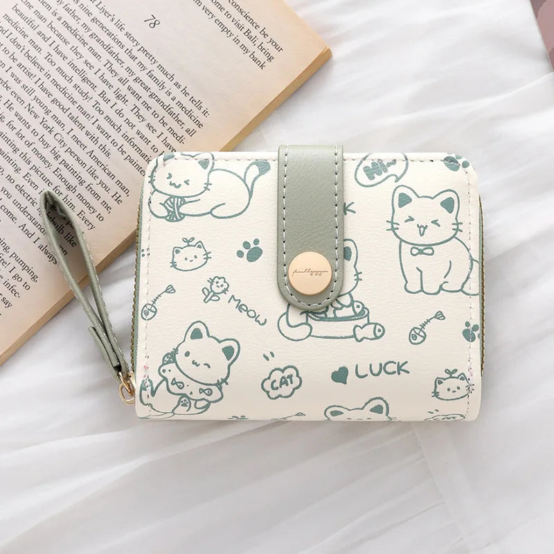 Helles beiges Münztaschen mit Reißverschluss, süßen Katzenillustrationen und Lederriemen.