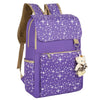 A purple canvas student backpack decorated with white stars and featuring a small teddy bear charm.
