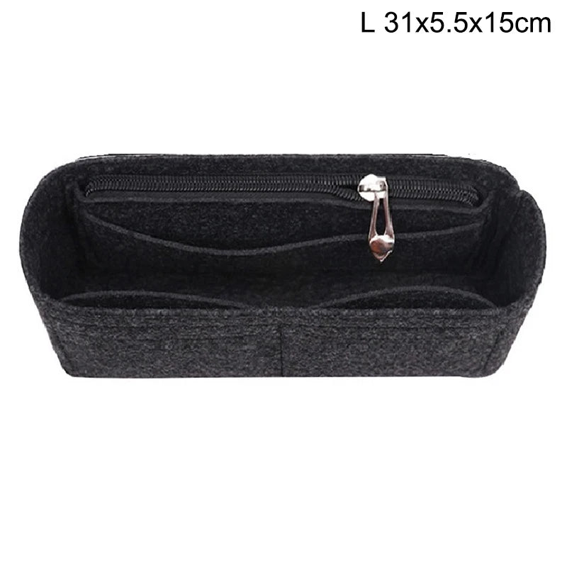 Black felt bag insert organizer with a zipper and a small metal charm
