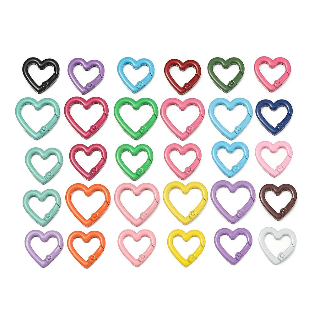 A collection of heart-shaped metal spring clasps in various colors and finishes.