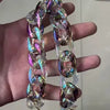 A close-up of a colorful resin bag strap and purse charm made of iridescent, swirling material.