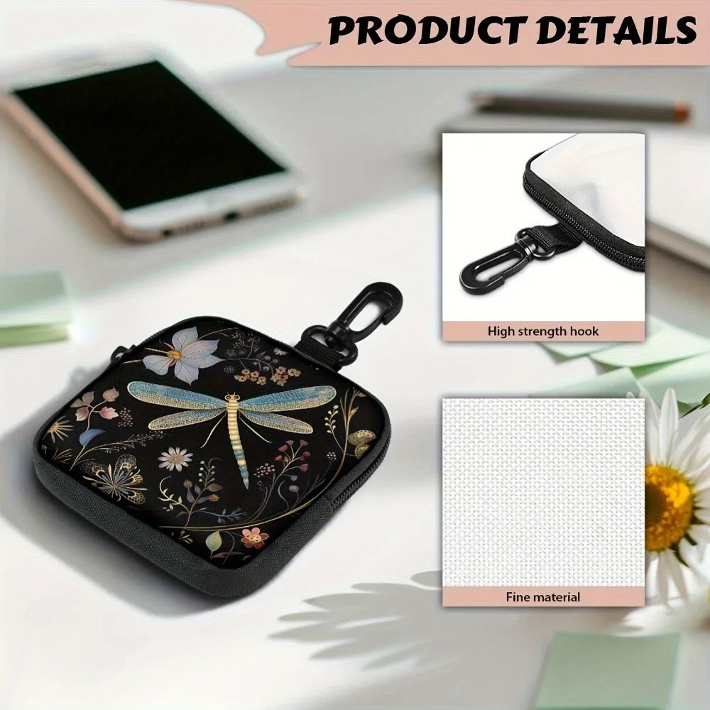 A black coin purse with a floral pattern and a hook closure is shown on a white surface.